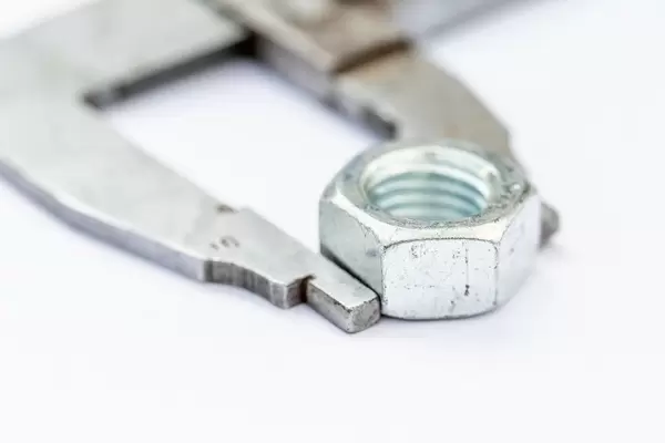 Close-up iron nut on white background with a wrench
