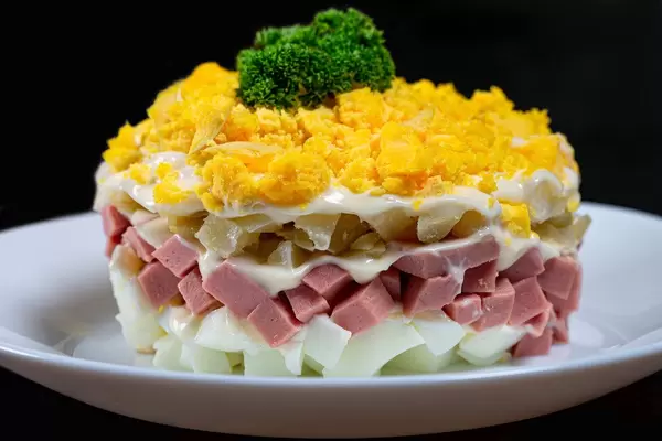 Close up layered salad with vegetables and ham on black background (Flip 2019)