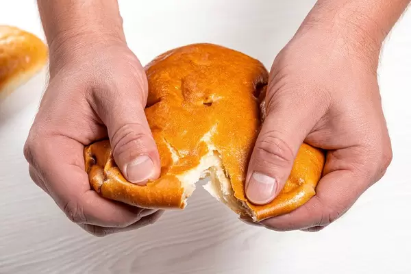 Close up male hands breaking fresh khachapuri