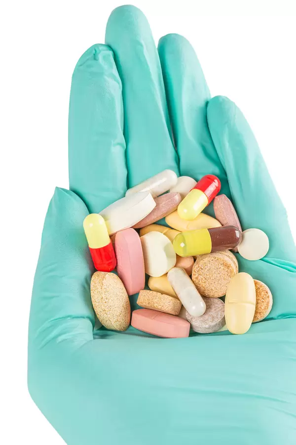 Close-up, many multi-colored tablets, pills and capsules in hand