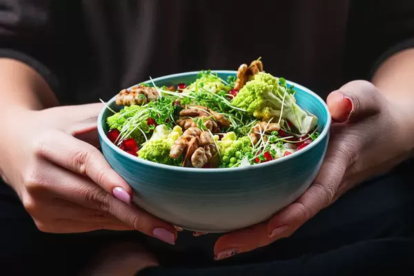Close-up of a bowl of salad in a woman's hands (Flip 2020)