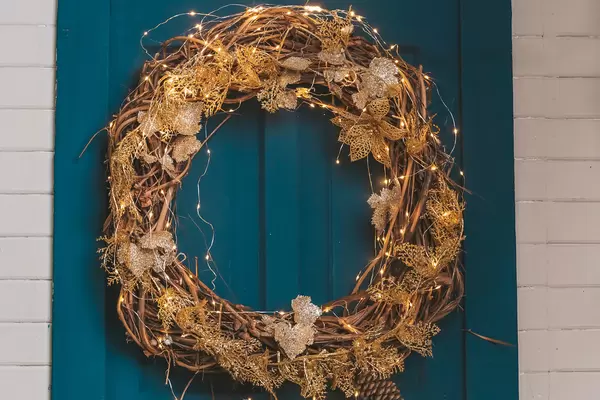 Close-up of a christmas wreath with a garland on a blue door
