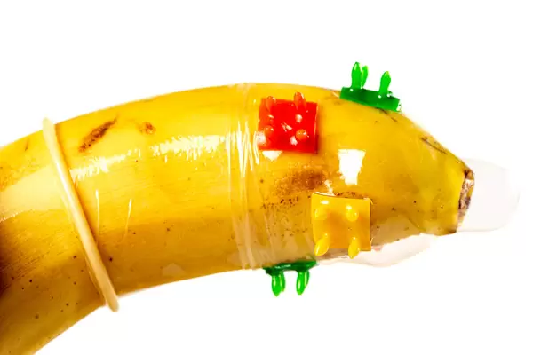 Close-up of a condom with spikes put on the banana