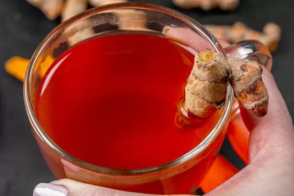 Close-up of a Cup of tea with turmeric in hand (Flip 2020)