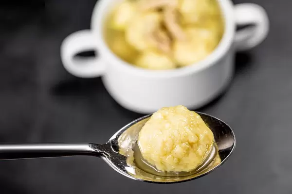 Close-up of a dumpling with soup in a spoon (Flip 2020)
