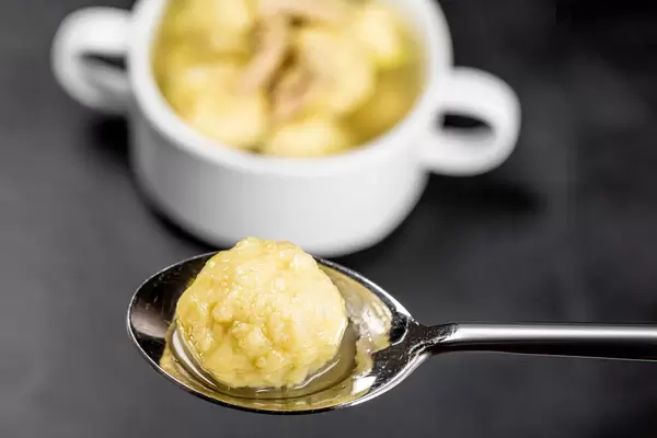 Close-up of a dumpling with soup in a spoon