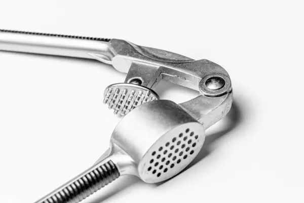 Close up of a garlic press on white background (Flip 2020)