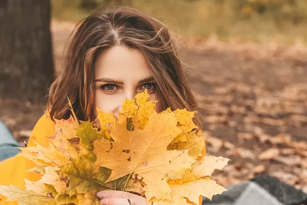 Close-up of a girl's face and yellow leaves