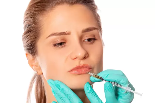 Close-up of a girl's lips and a syringe for injection