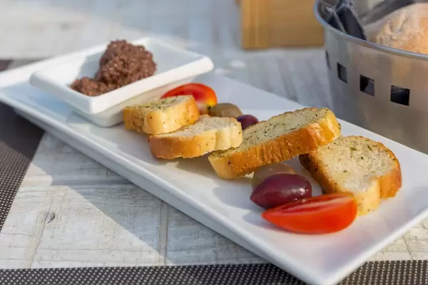 Close-up of a Greek starter: black olives, cherry tomatoes and minced olives in olive oil