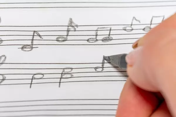 Close up of a hand with a black pencil learning to write notes