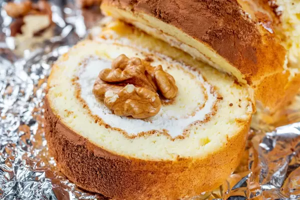 Close-up of a piece of biscuit with yogurt cream and walnuts
