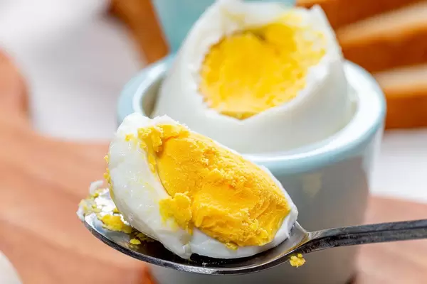 Close-up of a piece of boiled egg in a spoon. The concept of Breakfast (Flip 2019)