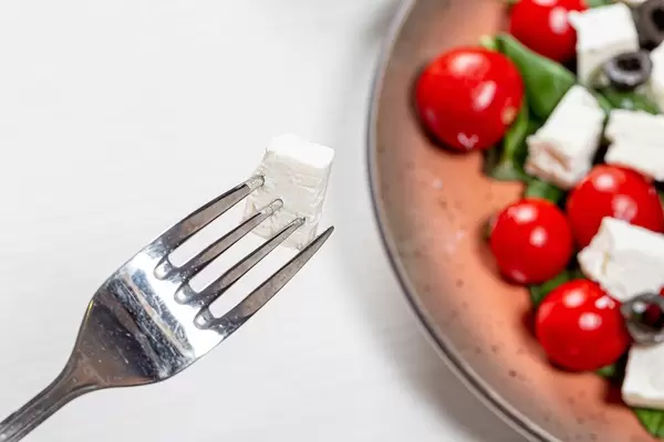 Close-up of a piece of feta cheese on a fork