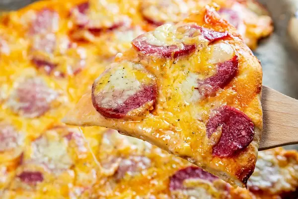 Close-up of a piece of hot pizza with cheese and sausage (Flip 2019)