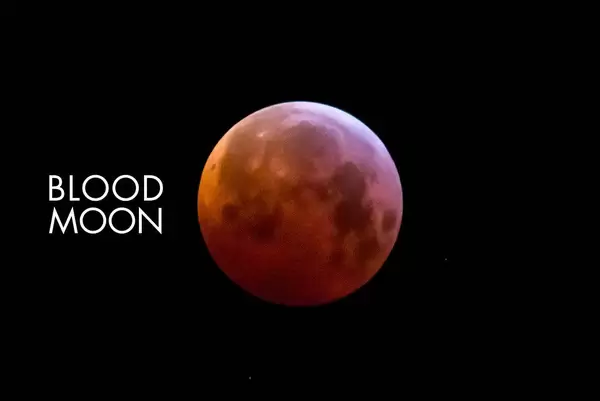 Close up of a red full moon with black background and picture title: Blood moon