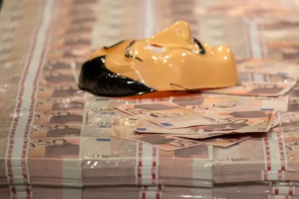 Close-up of a stack of money and a Salvador Dali mask, famous from Netflix crime show Money Heist