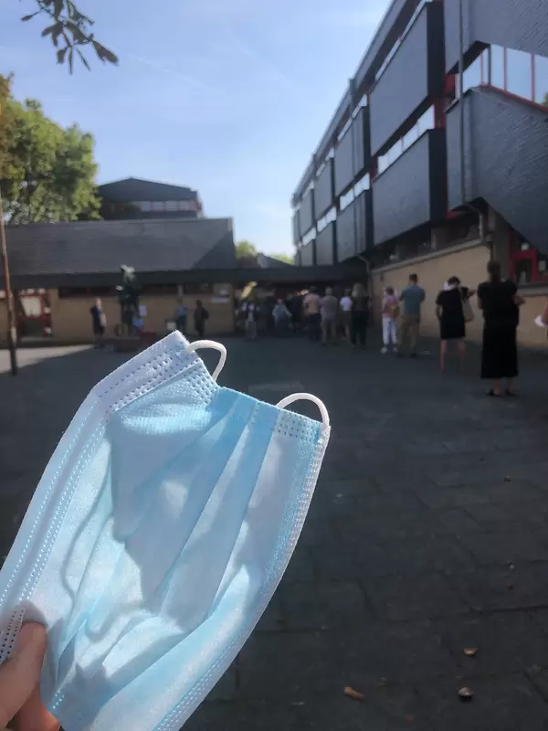 Close-up of a surgical mask held in the hand before queuing to vote in the local election in Cologne
