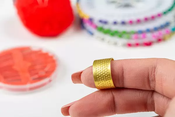 Close-up of a thimble for sewing on a woman's finger (Flip 2019)