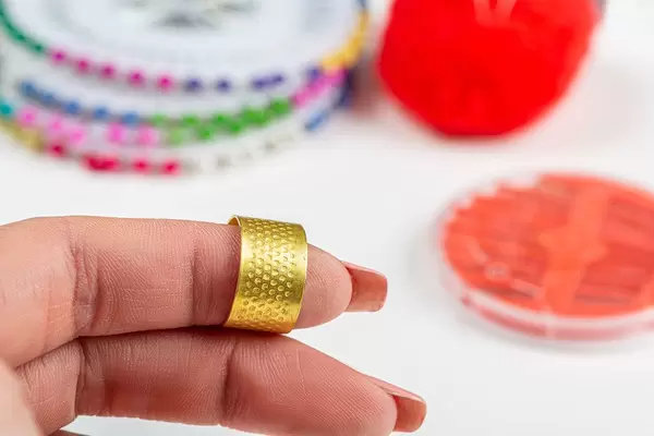 Close-up of a thimble for sewing on a woman's finger