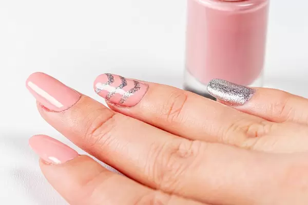 Close-up of a woman's pink manicure with nail polish (Flip 2019)