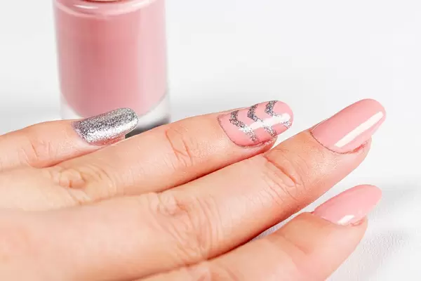 Close-up of a woman's pink manicure with nail polish