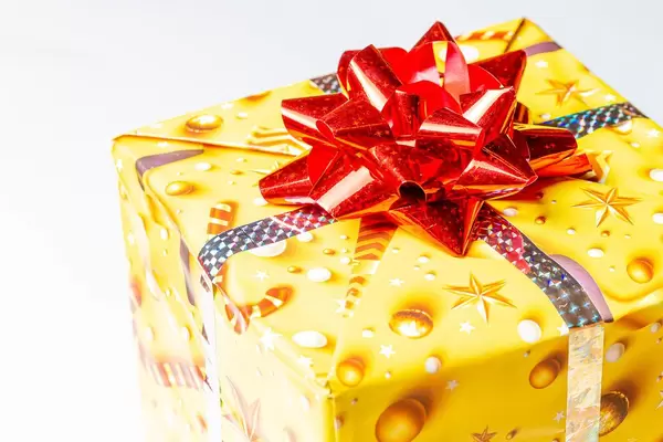 Close-up of a yellow gift box with a red bow (Flip 2020)