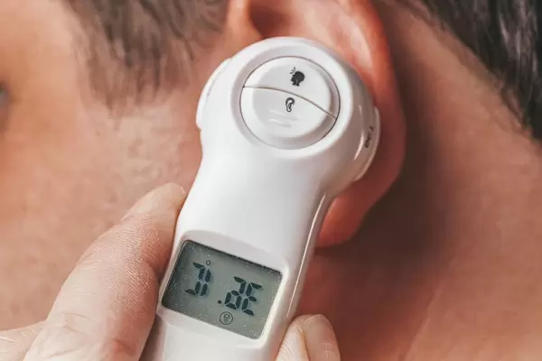 Close-up of an electric thermometer measures the temperature in a man's ear (Flip 2019)