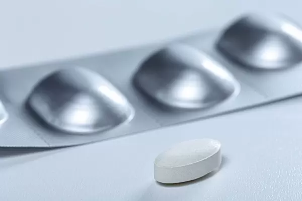 Close up of antibiotic tablet and blister behind her (Flip 2019)