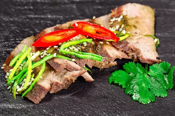 Close-up of baked beef with leek and hot chili pepper