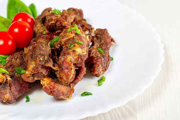Close up of baked lamb meat with vegetable garnish