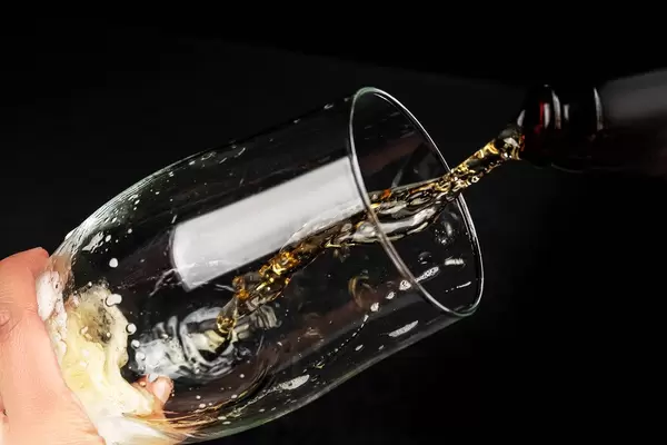 Close-up of beer pouring from a bottle into a beer glass