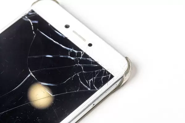 Close up of broken mobile phone screen on white background (Flip 2019)