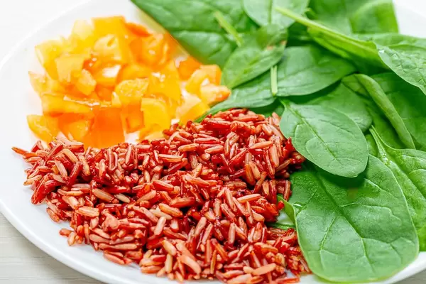 Close up of brown rice with spinach leaves and chopped bell peppers (Flip 2019)