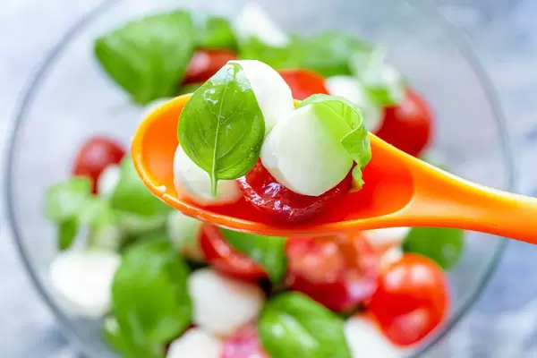 Close-up of Caprese salad in orange spoon (Flip 2019) (Flip 2019)