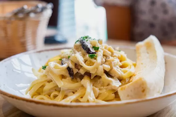 Close up of carbonara with sliced bread on side