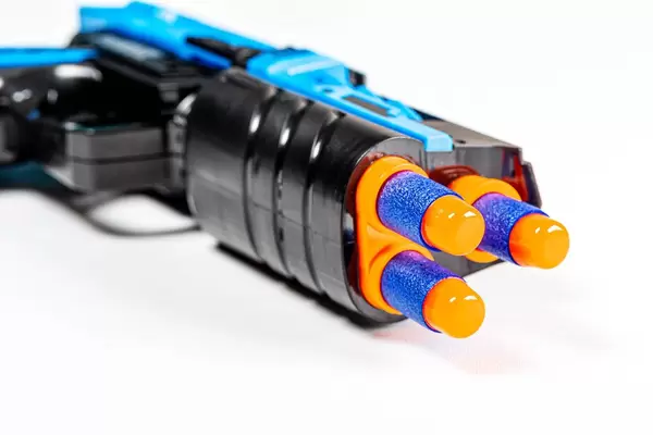 Close-up of cartridges in a toy gun on white