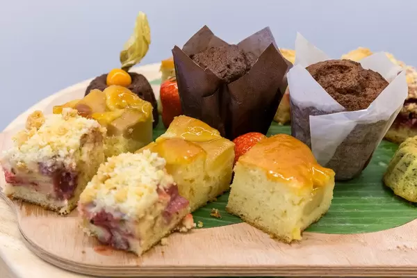 Close-up of chocolate muffins and various pieces of fruit cake on a kitchen board at the buffet table of AXA Barcamp OMWest 2019 in Cologne, Germany