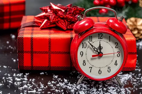 Close up of Christmas background with red alarm clock and gift boxes