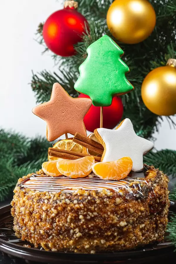 Close-up of Christmas cake with gingerbread and tangerines on the background of the Christmas tree (Flip 2019)