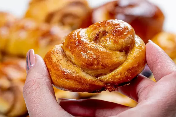 Close up of cinnamon bun in woman's hand (Flip 2019)