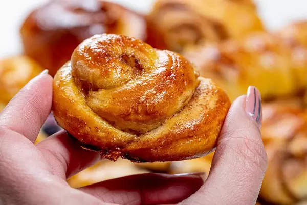Close up of cinnamon bun in woman's hand