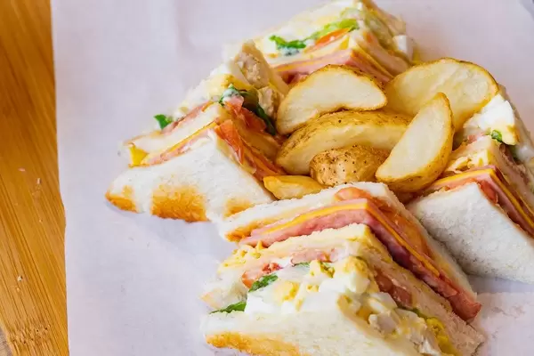 Close up of clubhouse sandwich with potato wedges (Flip 2019)