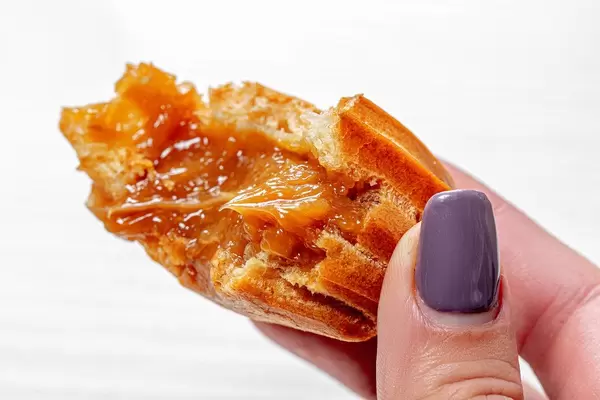 Close up of eclair with condensed milk in a woman's hand (Flip 2019)