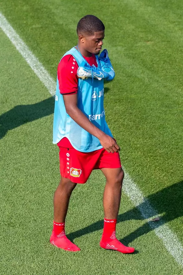 Close-up of football player of the German club Bayer 04 Leverkusen walks barefoot over the green artificial gras