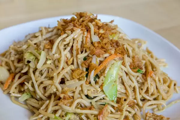 Close-up of fried Asian noodles with fried egg and lots of vegetables, as vegetarian lunch