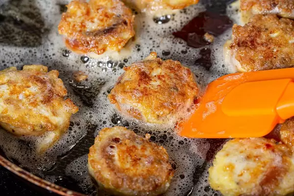 Close up of fried bagels with meat filling in a frying pan (Flip 2019)