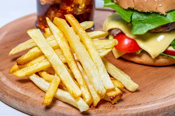 Close - up of fried potatoes, behind him a Burger and a glass of coke (Flip 2019)