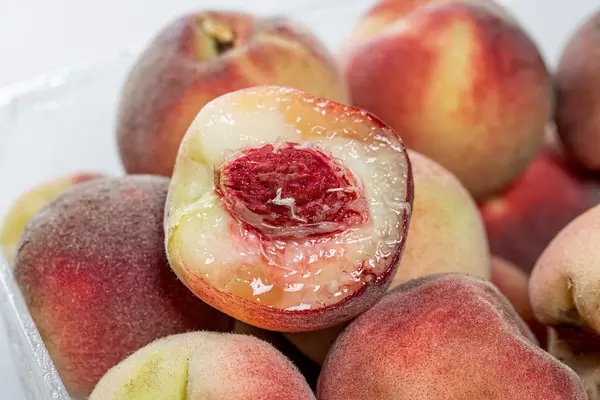 Close-up of half a peach on the background of whole peaches