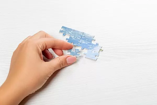 Close up of hand placing piece in puzzle (Flip 2019)